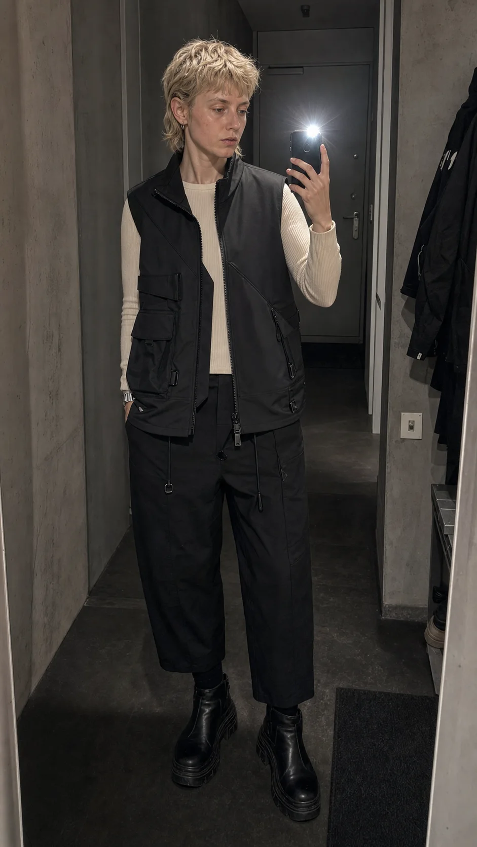 Berlin mirror selfie styling image showing the Clothixpack CXP-A107 Sling Waterproof Vest over a cream ribbed top and cropped black trousers.